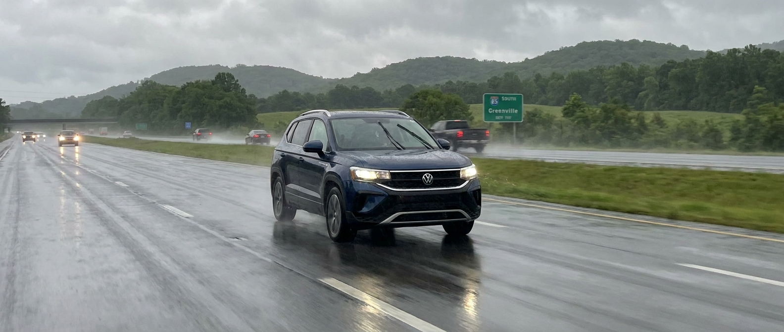 2026 Volkswagen Taos driving on a wet Upstate South Carolina highway in summer rain near Duncan and Lyman